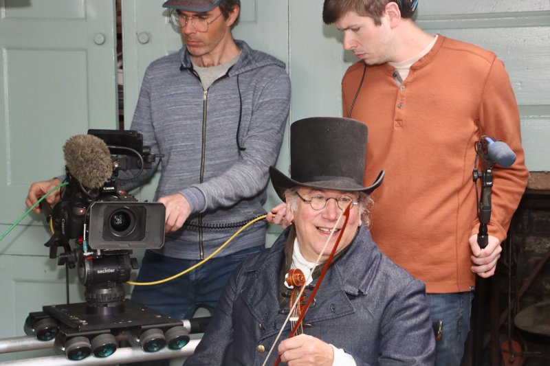 Actor Chuck Krepley, middle, waits for the director to say, “action” as Jesse Beecher, cinematographer, l, and John McCulloch, associate producer, set up camera shots inside the Sussex Tavern.